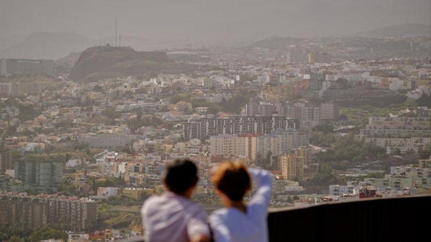 Una pareja observa la ciudad en una jornada con calima.