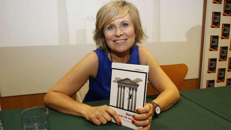 La periodista María Rey con un ejemplar de su libro.