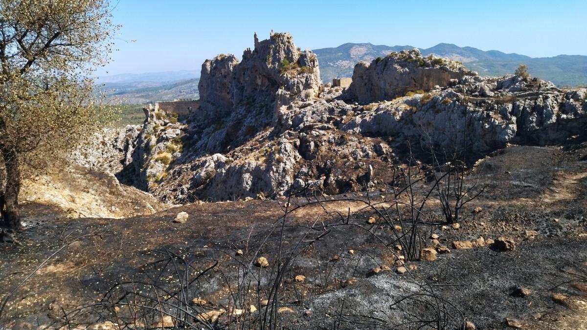El estrago del fuego y, al fondo, el castillo de Benissili