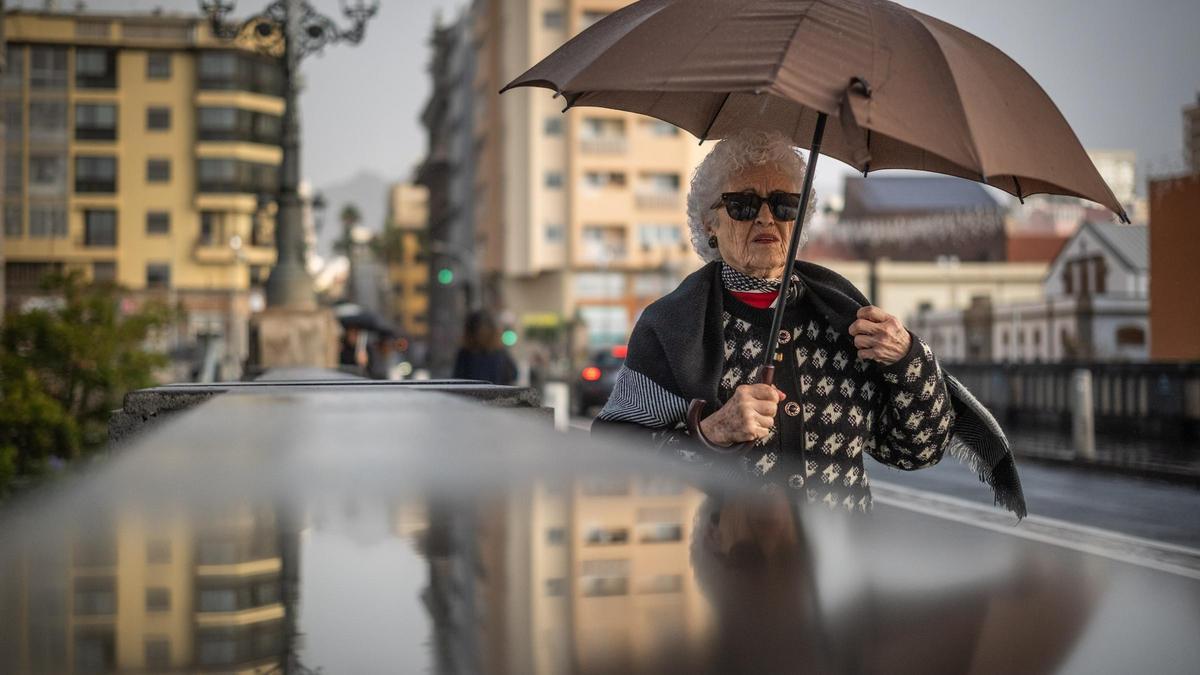 Una mujer se refugia de la lluvia que trajo la borrasca Emilia