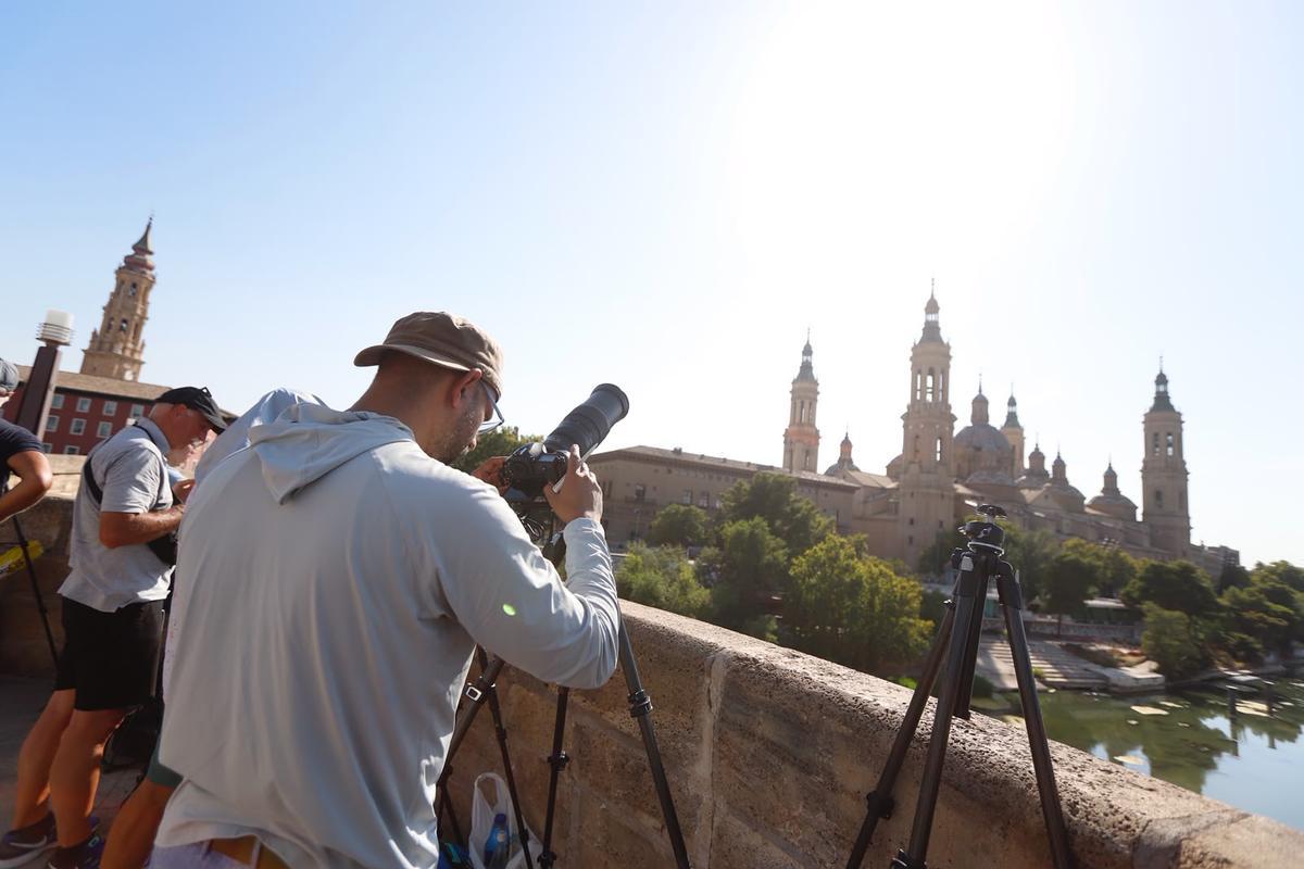 Un aficionado se prepara para vivir el eclipse en Zaragoza desde el puente de Piedra.
