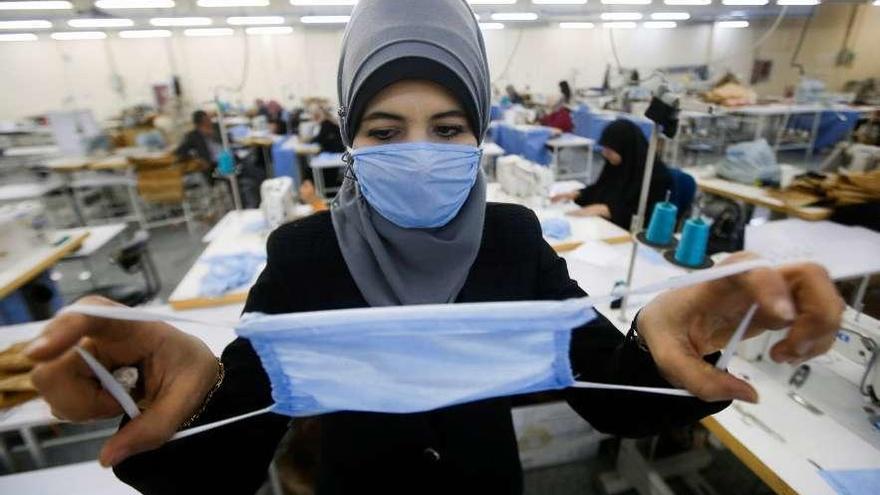 Una trabajadora textil en Babilonia (Irán), con una de las mascarillas que fabrican.