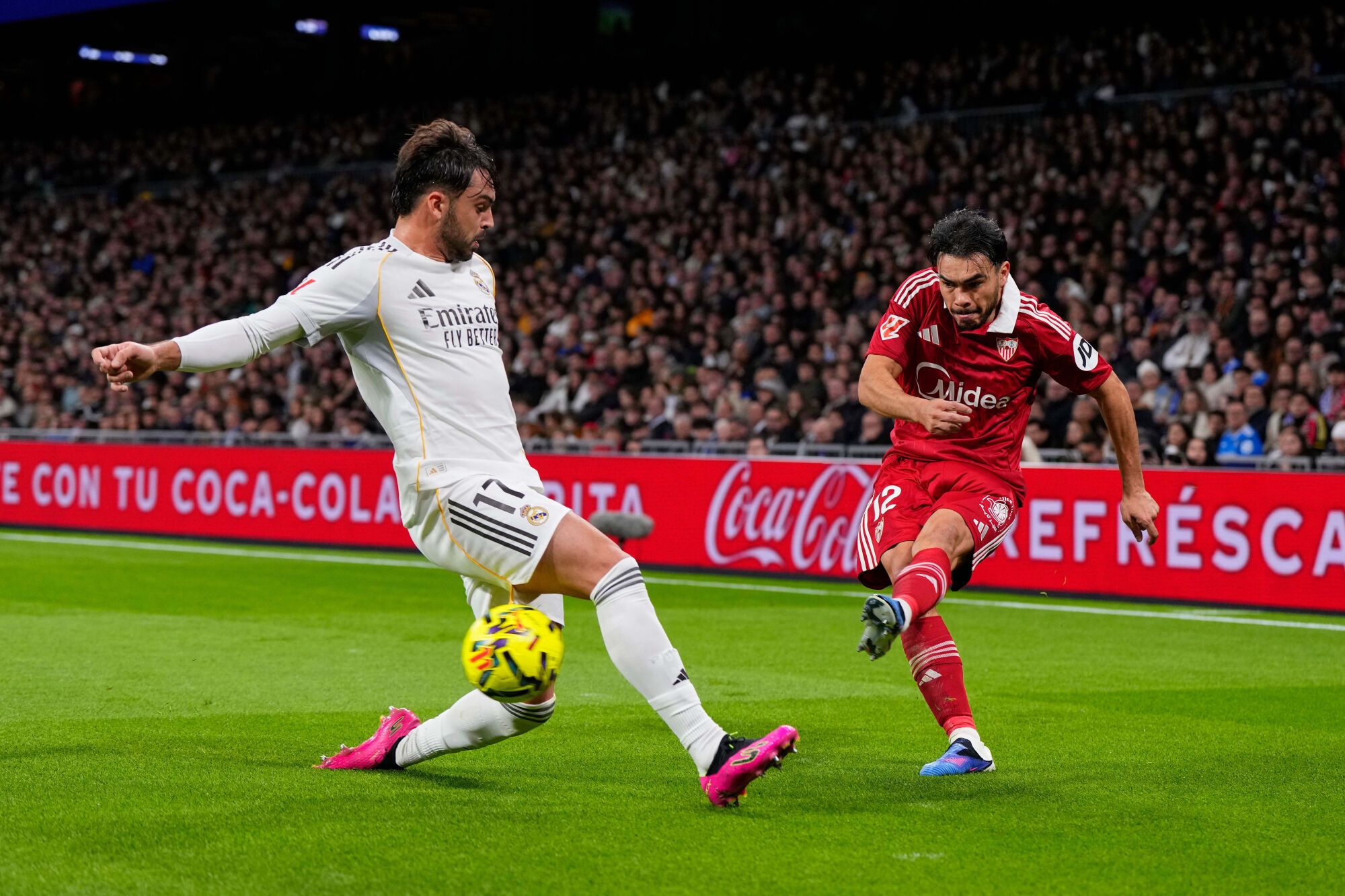 Sevilla's Gabriel Suazo, right, crosses the ball as Real Madrid's Raul Asencio attempts to block during the Spanish La Liga soccer match between Real Madrid and Sevilla in Madrid, Spain, Saturday, Dec. 20, 2025. (AP Photo/Manu Fernandez). EDITORIAL USE ONLY/ONLY ITALY AND SPAIN