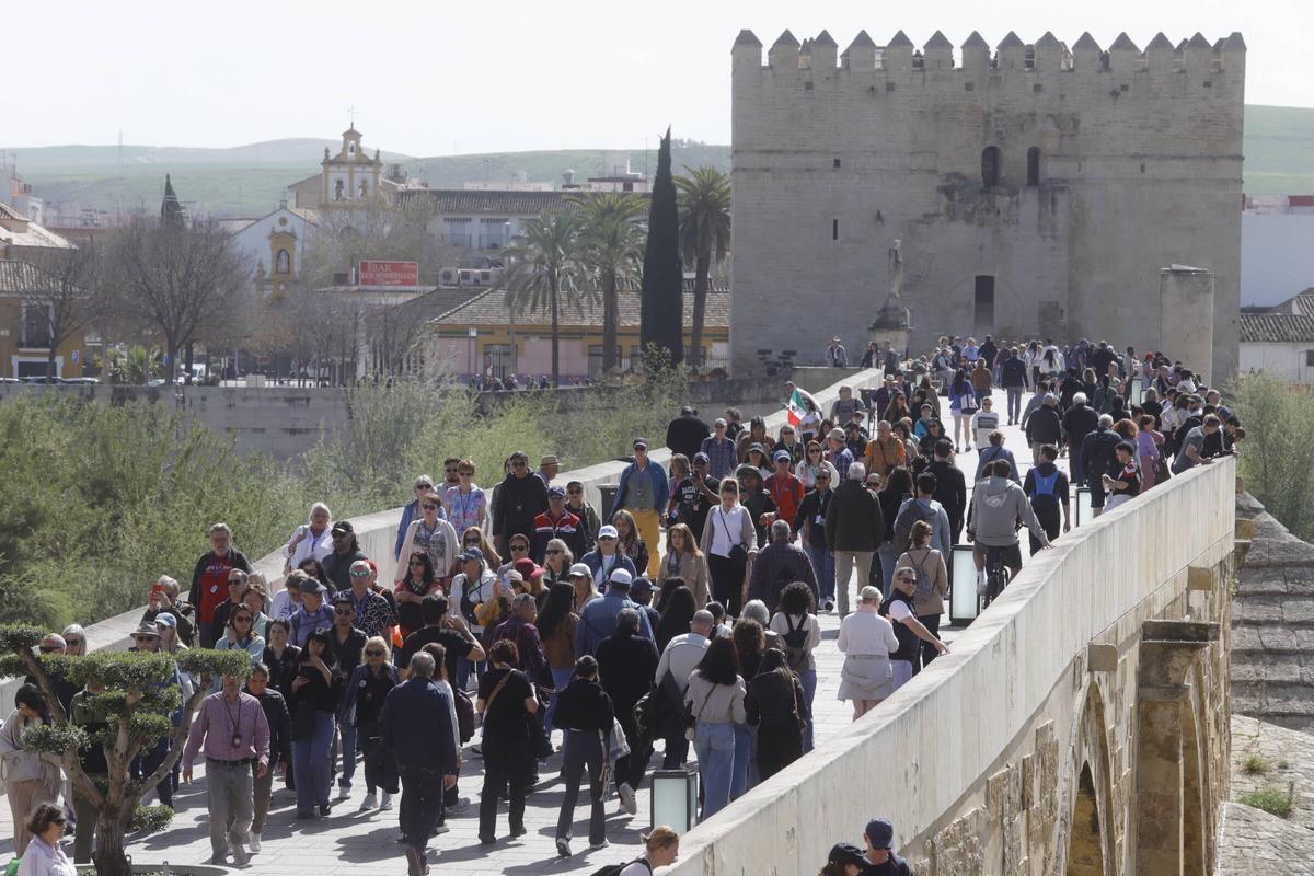 Multitud de turistas por el Puente Romano de Córdoba, que conecta con el casco histórico.
