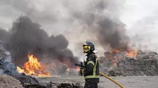 Los bomberos trabajan en la extinción de un incendio en una planta de cartones en Valladolid