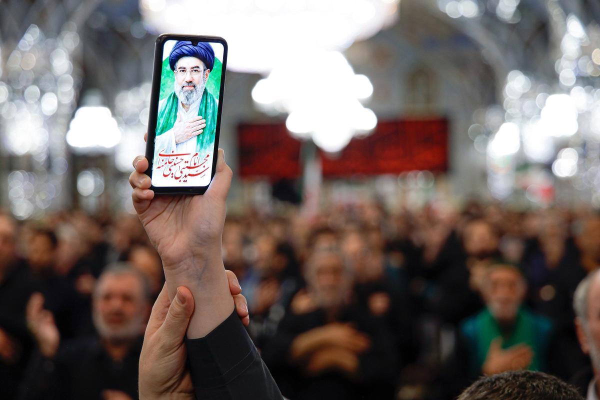 Un ciudadano sostiene imágenes del nuevo líder supremo de Irán, el ayatolá Mojtaba Jamenei