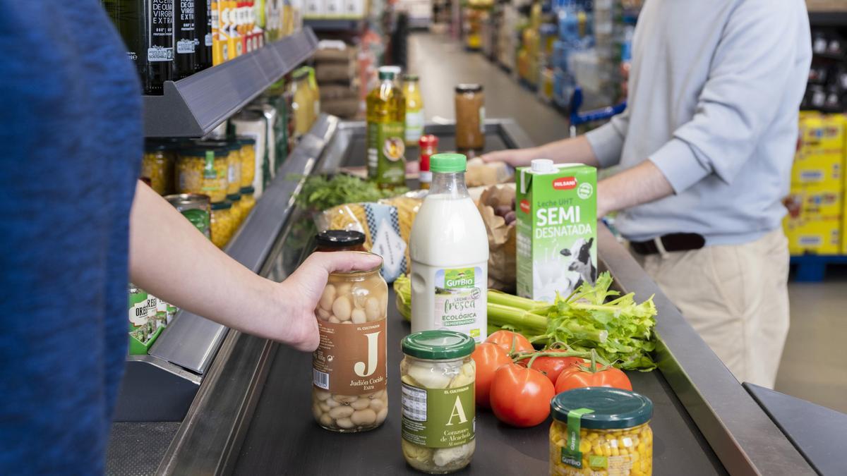 Cliente pasando productos por la caja de un supermercado Aldi.