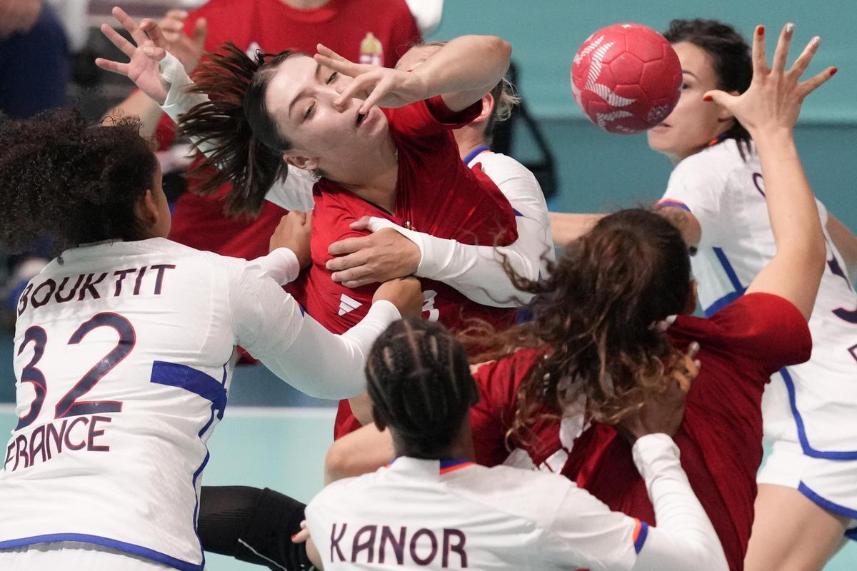 La húngara Petra Vamos, en el centro, intenta rematar contra las defensoras francesas durante el partido de balonmano femenino que enfrentó a los equipos de Hungría y Francia en los Juegos Olímpicos de Paris 2024