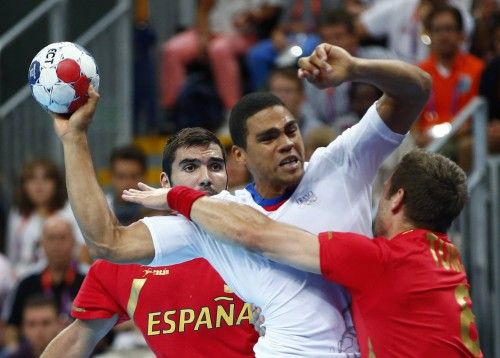 France's Daniel Narcisse is blocked by Spain's Victor Tomas Gonzalez as they are watched by Spain's Eduardo Gurbindo Martinez in their men's handball quarterfinals match in London