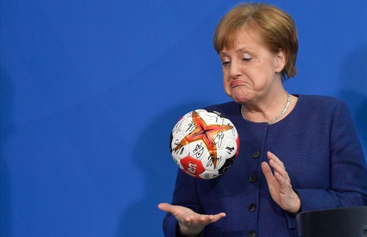 Angela Merkel, juega con una pelota de  balonmano durante la recepción al equipo nacional alemán de balonmano en Berlín.