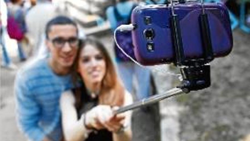 Una parella, fent-se una fotografia amb un pal de «selfie».