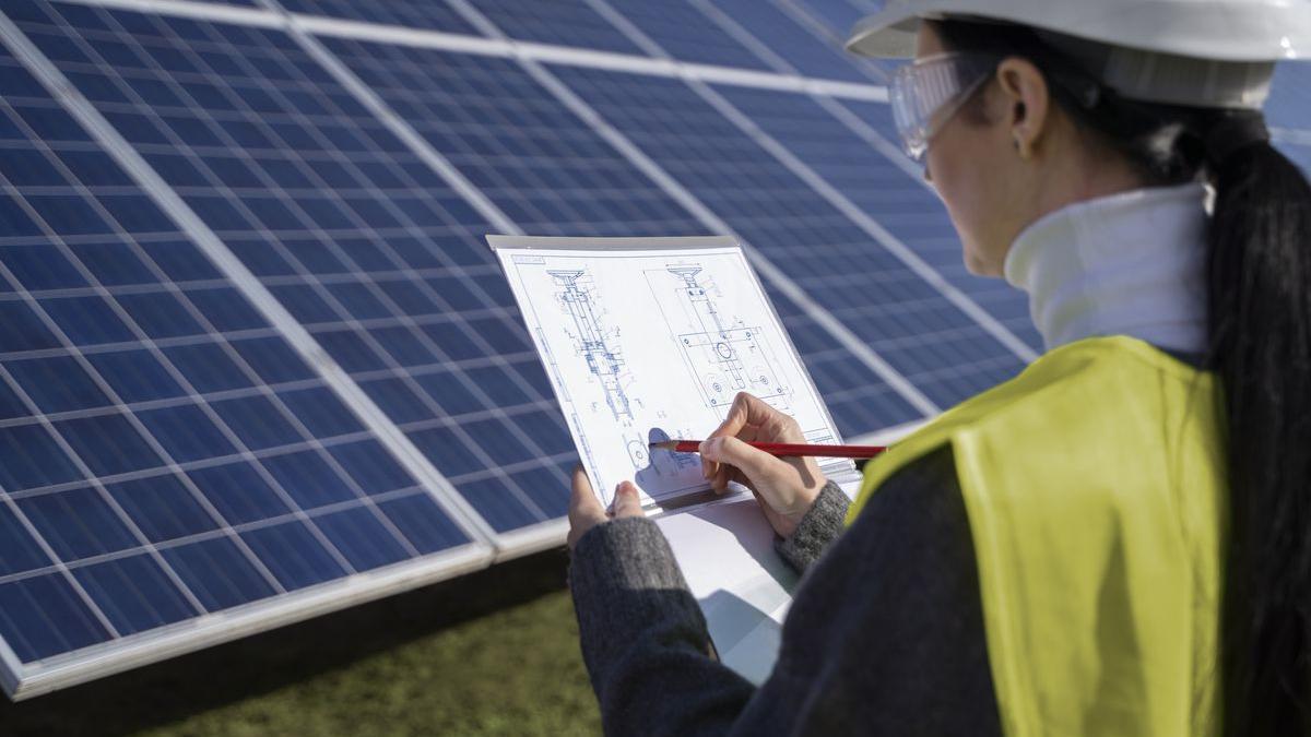 Una alumna junto a unas instalaciones de energía fotovoltaica, en imagen de archivo.