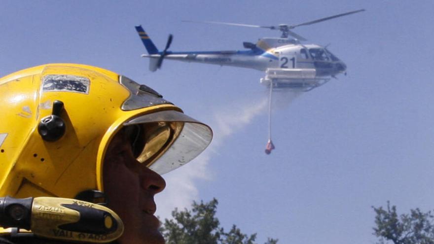 Un helicòpter al fons en un incendi a Quart, en una imatge d&#039;arxiu.