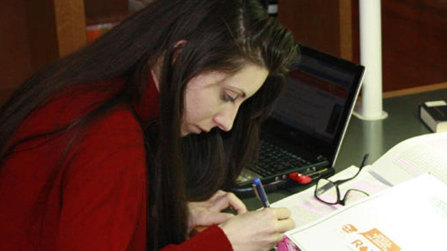 Una mujer estudia en una biblioteca.