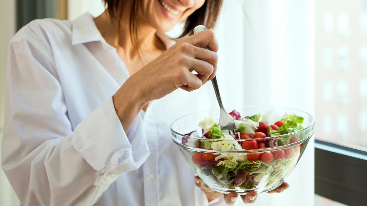 Una mujer comiendo una ensalada