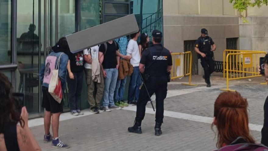 Varios estudiantes de la Acampada por Palestina siendo identificados por agentes de Policía, al lado del rectorado de la UV.