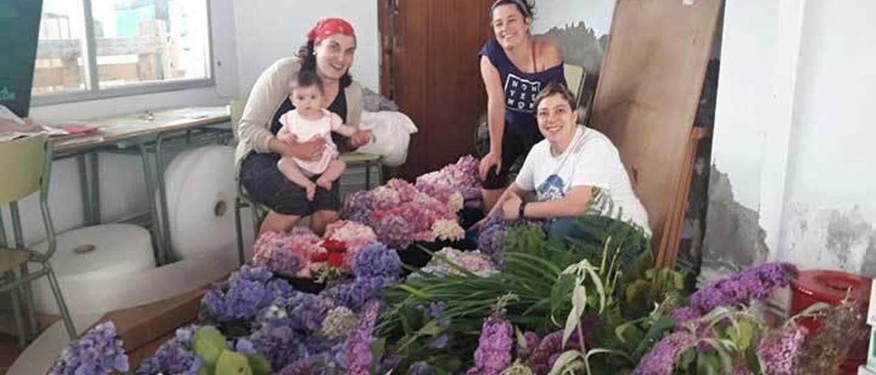 Integrantes de &quot;Entaína Ribeseya&quot;, ayer, acopiando flores para enramar fuentes.