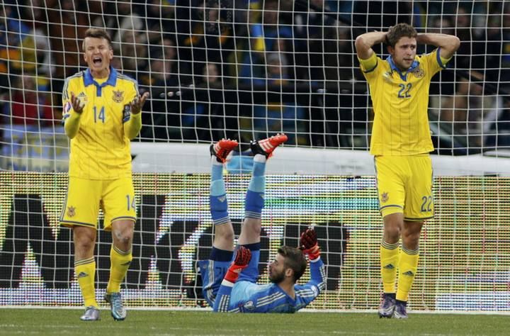 Ukraine's Ruslan Rotan and Artem Kravets react after a missed chance as Spain's goalkeeper David de Gea lies on the pitch during their Euro 2016 group C qualifying soccer match at the Olympic stadium in Kiev