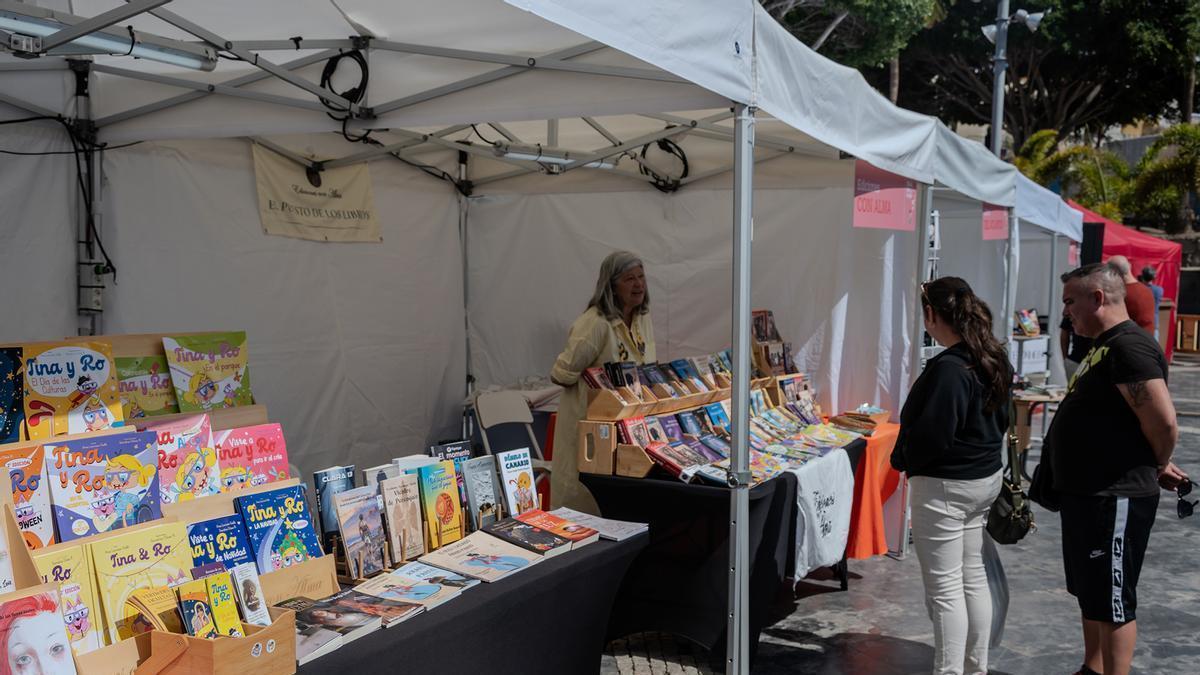 Dos personas frente a uno de los estands de la Feria del Libro.