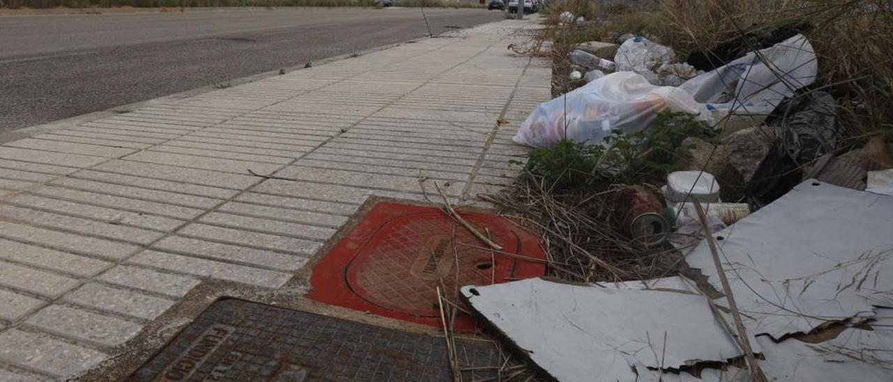 Una boca de incendio de un polígono industral de Alzira rodeada de basura y maleza, en una imagen de ayer.