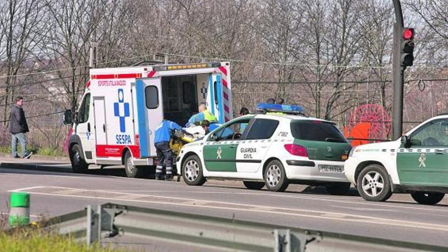 Los efectivos sanitarios introducen al herido en la ambulancia.