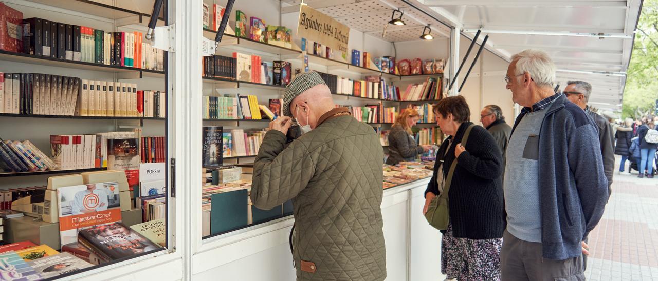 Cacereños miran libros en la Feria del Libro de Cáceres, ayer.