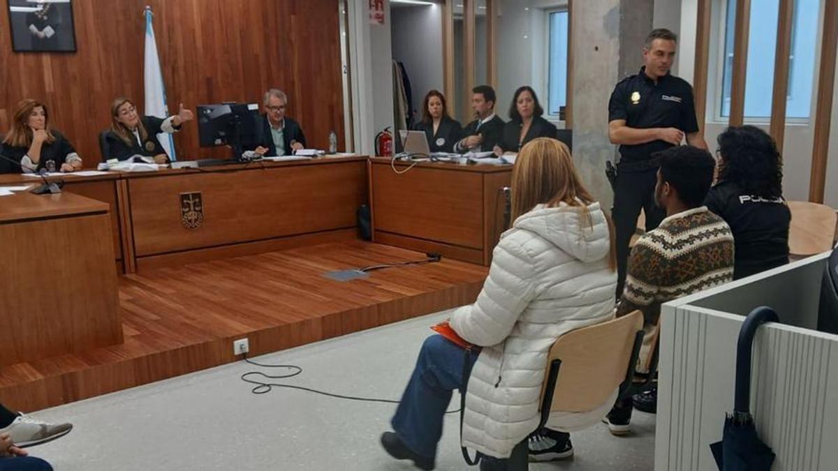 El acusado, escoltado por una agente nacional y su traductora jurada de portugués.