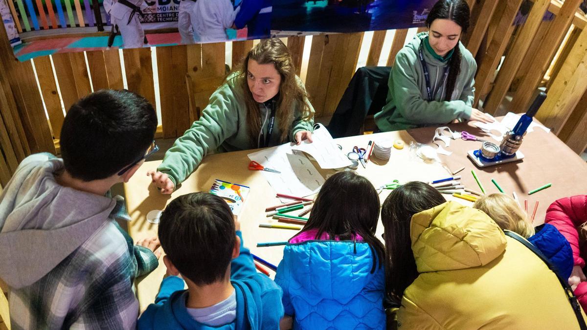 Un grup de nens i nenes fan manualitats en un dels estands del Campi