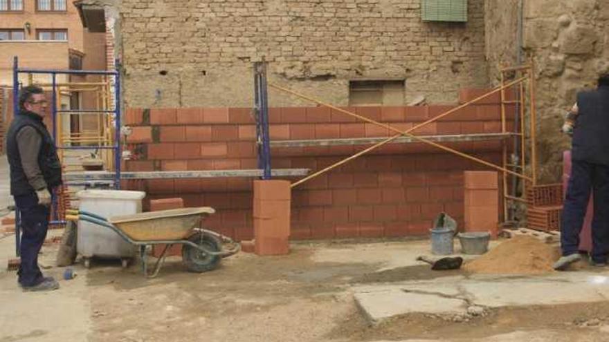 Los operarios trabajan en la reconstrucción del local junto al templo.