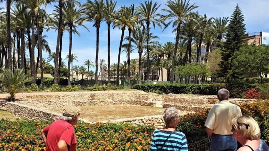 Unos turistas observan los restos de la Casa Romana en el parque de El Palmeral.