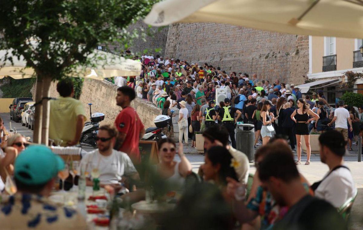 Una terraza con turistas y, al fondo, la concentración de protesta. | M.S.