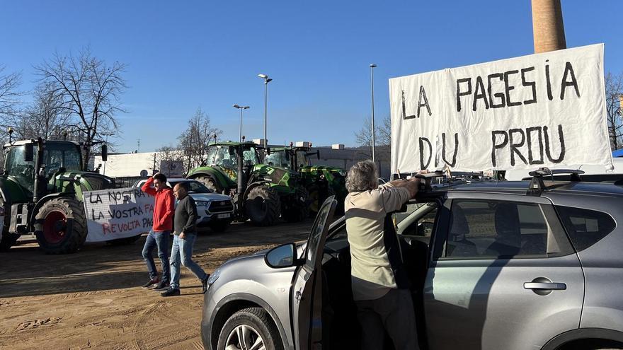 Un dels pagesos prepara un cartell al recinte firal El Sucre on es pot llegir: 'La pagesia diu prou'