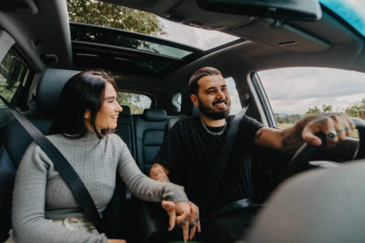 Una pareja cogiéndose la mano mientras viajan en coche.