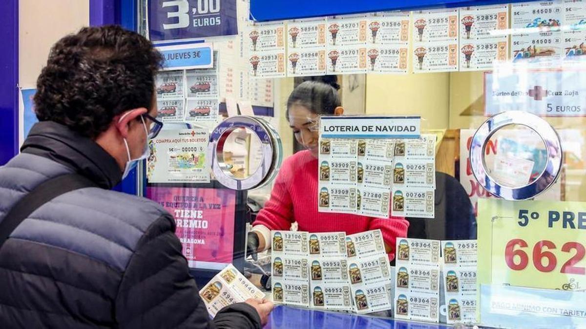 Una persona compra un dècim per al Sorteig Extraordinari de la Loteria de Nadal.