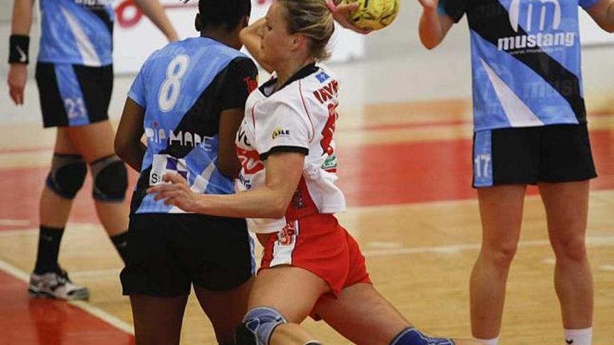 Una jugadora de FEVE Gijón intenta un lanzamiento ante varias jugadoras del Mustang.