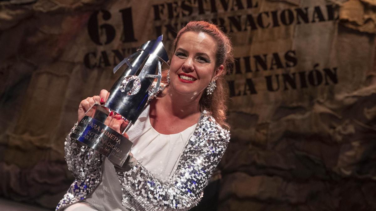 La cantaora pacense Esther Merino posa con la Lámpara Minera tras proclamarse vencedora del LXI Festival Internacional del Cante de las Minas de La Unión.