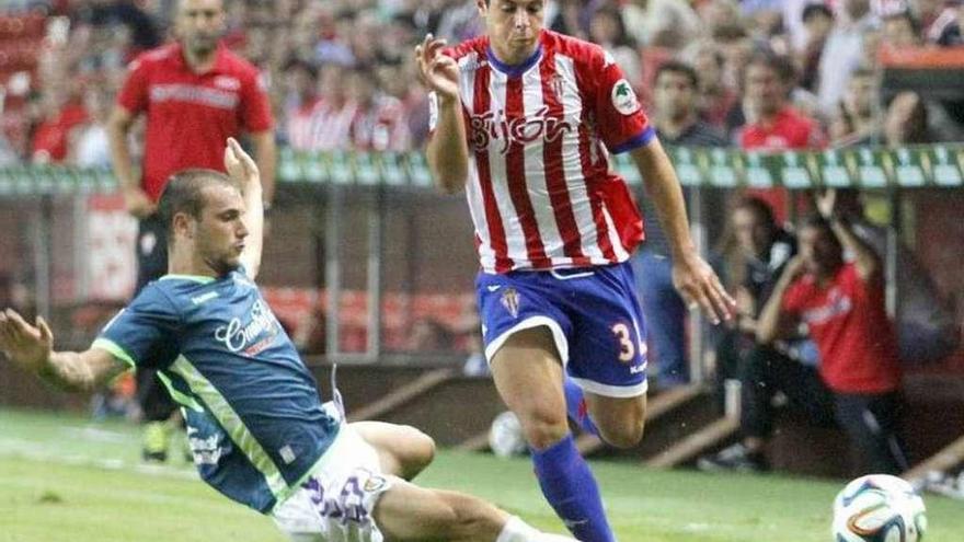 Álvaro Bustos superando la entrada de un rival del Valladolid en su etapa en el Sporting. // J.J.