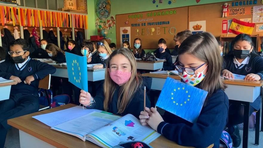 Martina Morán y Adriana Rodríguez junto a sus banderas de la unión Europea en la clase de 4ºA del Amor de Dios
