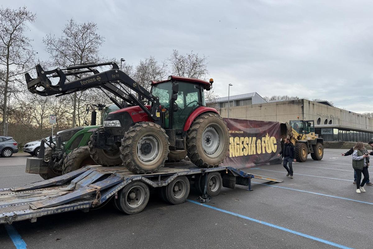 Instants abans de sortir des de Girona els pagesos carreguen els tractors al tràiler