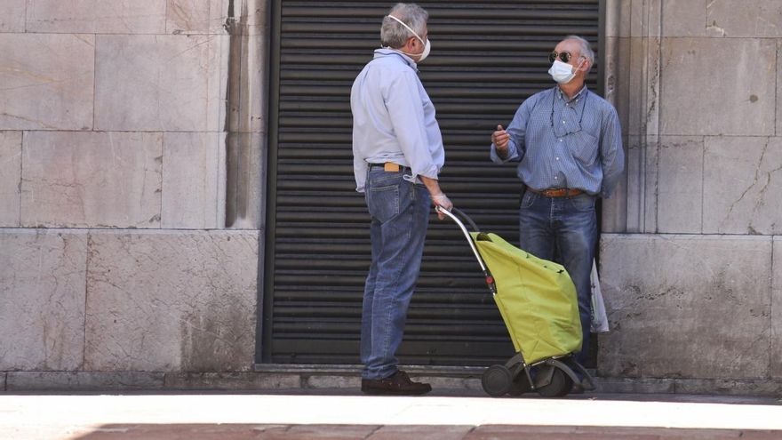 Gente por la calle con mascarilla.