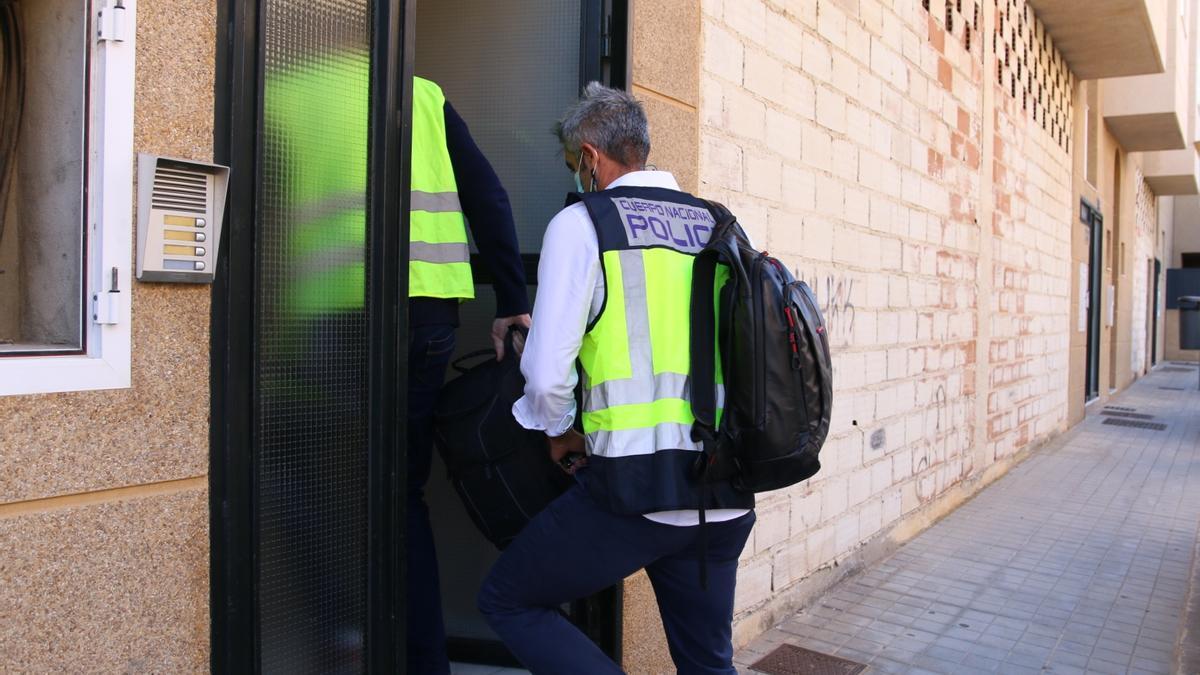 Dos agentes de la policía, en el portal de la vivienda donde se hallaron los cuerpos de los menores y su madre.