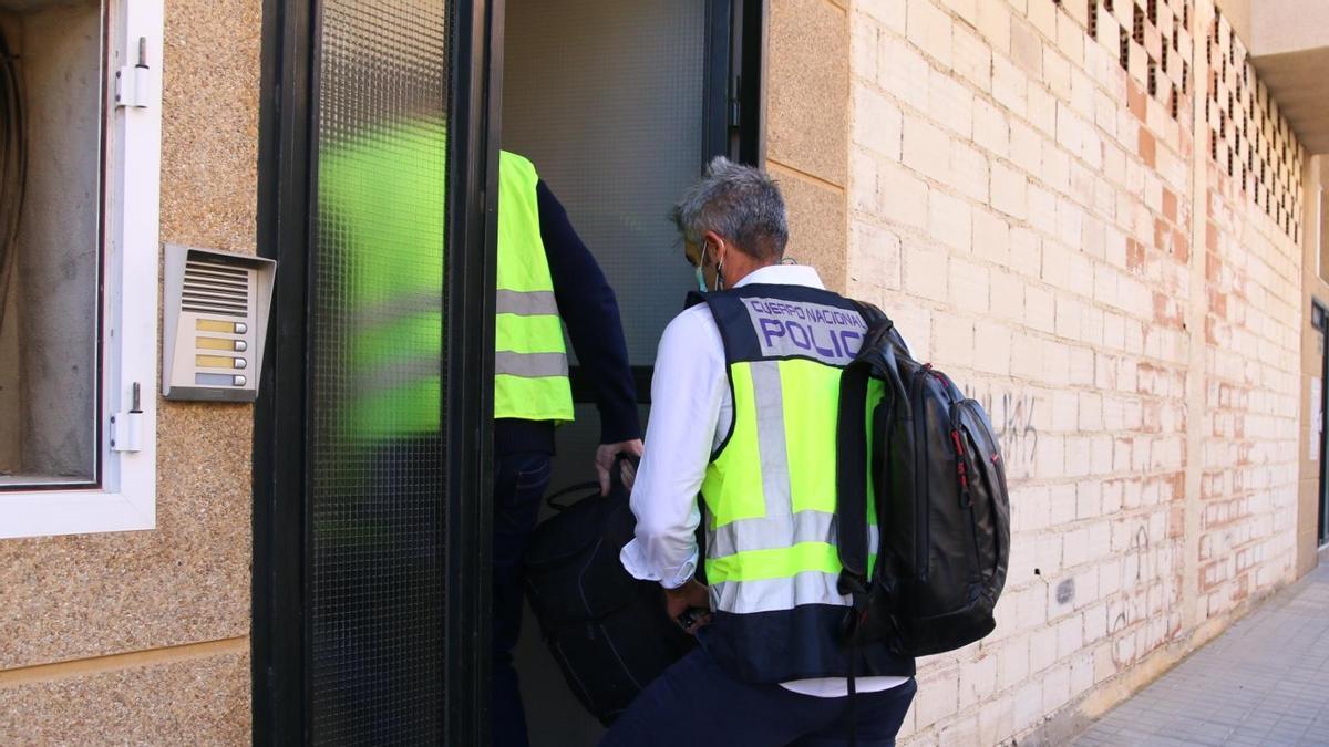 Dos agentes de la policía, en el portal de la vivienda donde se hallaron los cuerpos de los menores y su madre.