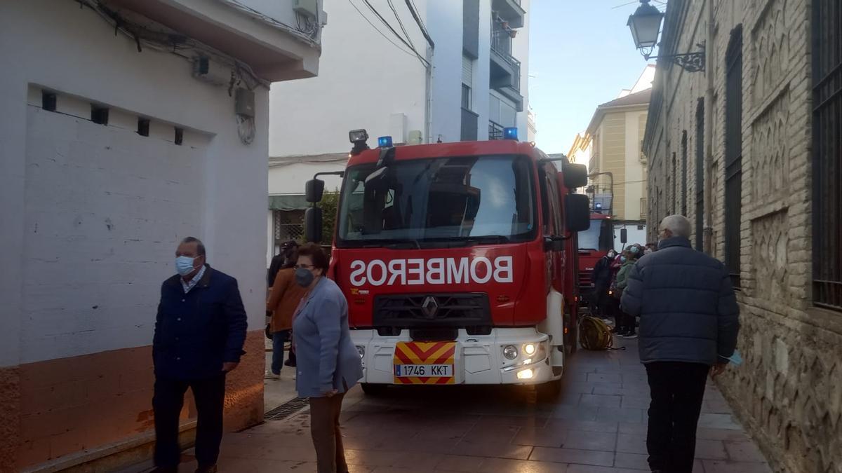 Los bomberos, esta mañana, actuando en el incendio de la calle Peñuelas de Lucena.