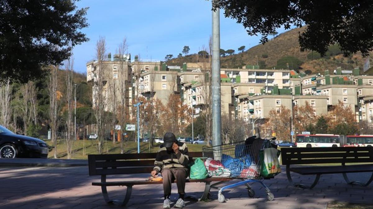 Un indigente, en un banco de la plaza Karl Marx, en Nou Barris.