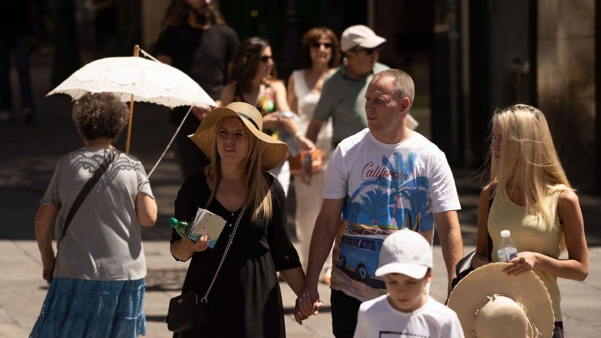 Los zamoranos se protegen del sol con sombreros, botellas de agua y paraguas.