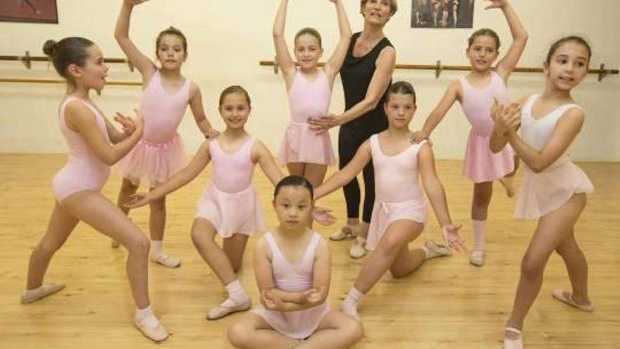 La profesora Alicia Broseta sujeta a Daniela Guzzardo mientras preparan el festival de fin de curso.