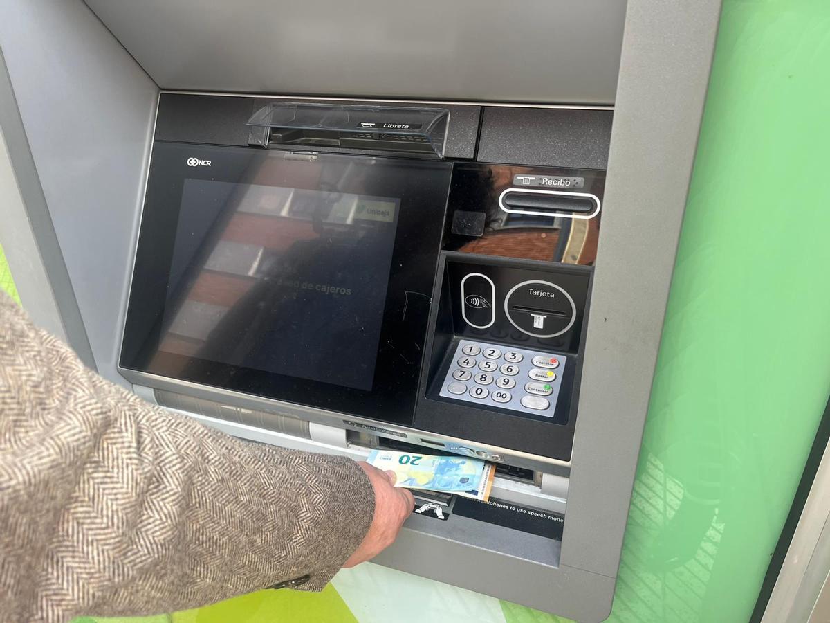 Un hombre lorga sacar dinero en un cajero tras la incidencia en Unicaja