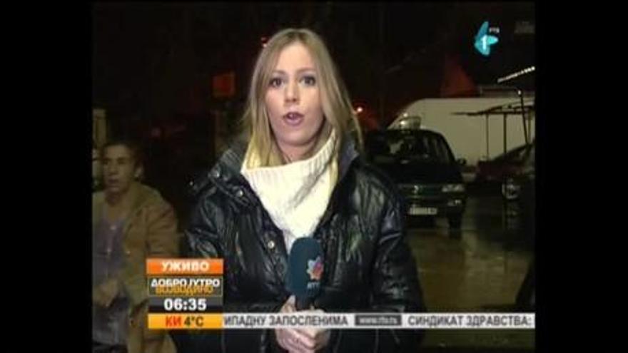 Un desconocido muestra una pistola a una reportera de televisión serbia en pleno directo