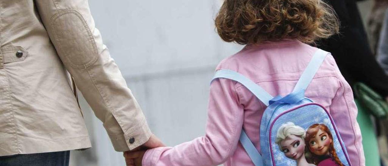 Una mama, recogiendo a su hija a la salida del colegio en un centro de A Coruña. // 13fotos