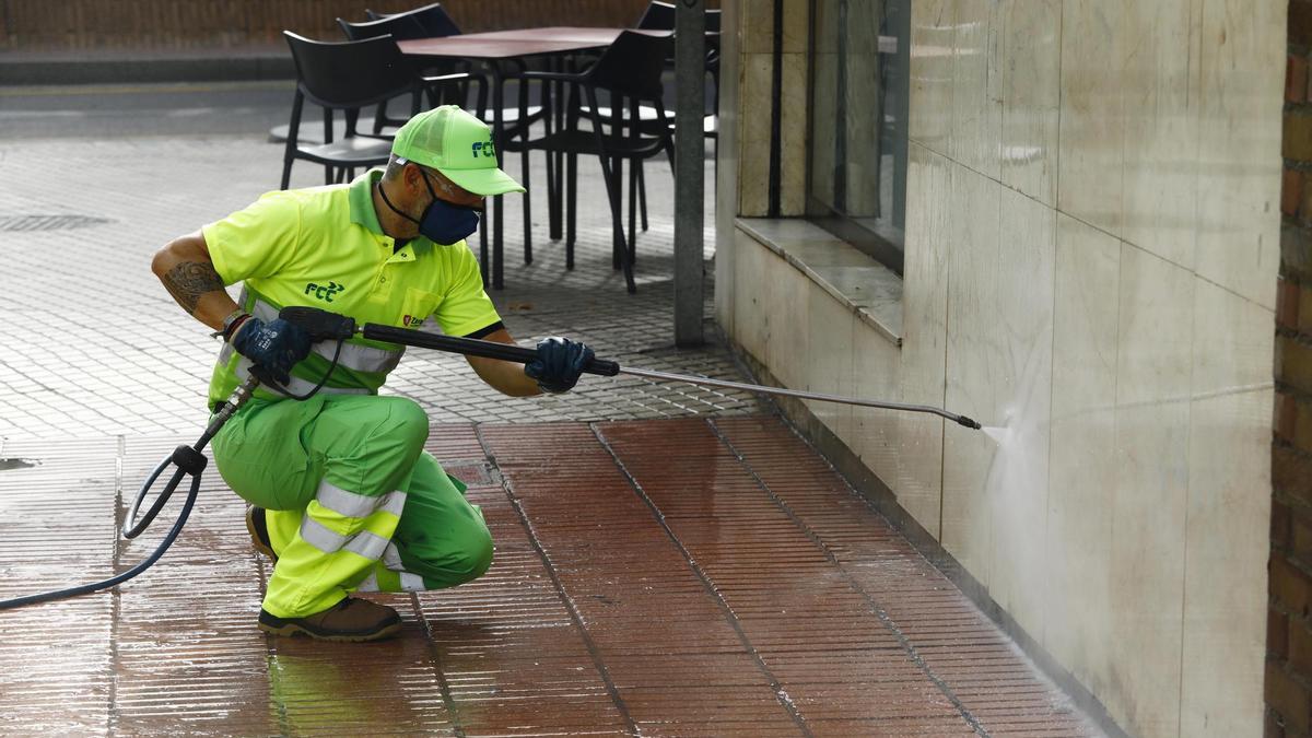 Un operario de FCC retira unas pinturas y manchas de ciudad en las calles de Zaragoza.